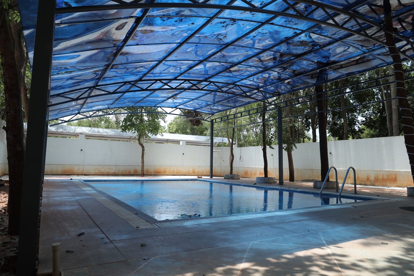 Covered swimming pool under a blue canopy